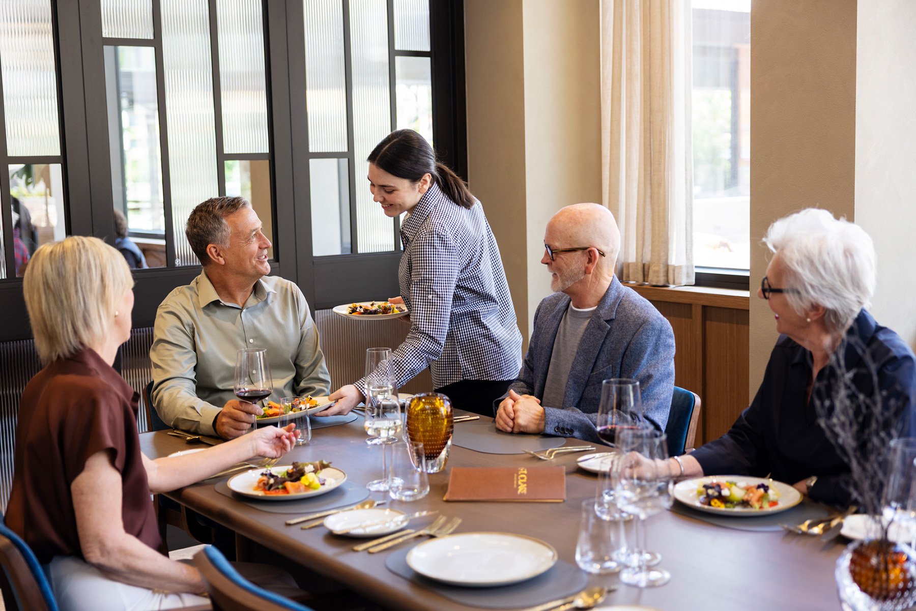 Waitress serving residents in St. Clare private dining room